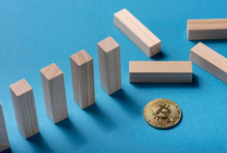 High-angle view of domino pieces arranged with Bitcoin symbol illustrating structural risk in digital asset markets