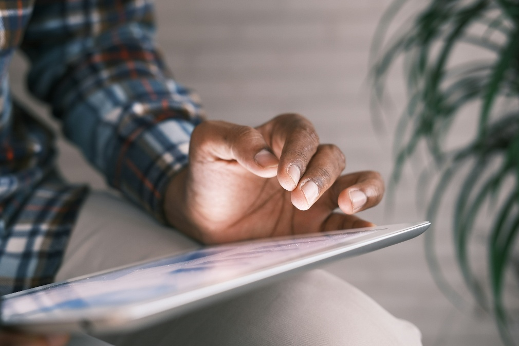Professional reviewing digital financial records and market information on a tablet device