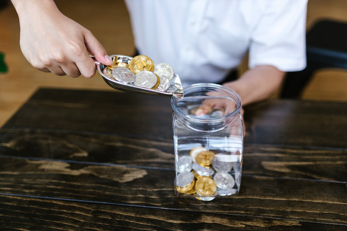 Putting Coins in a Container Using a Silver Small Shovel.
