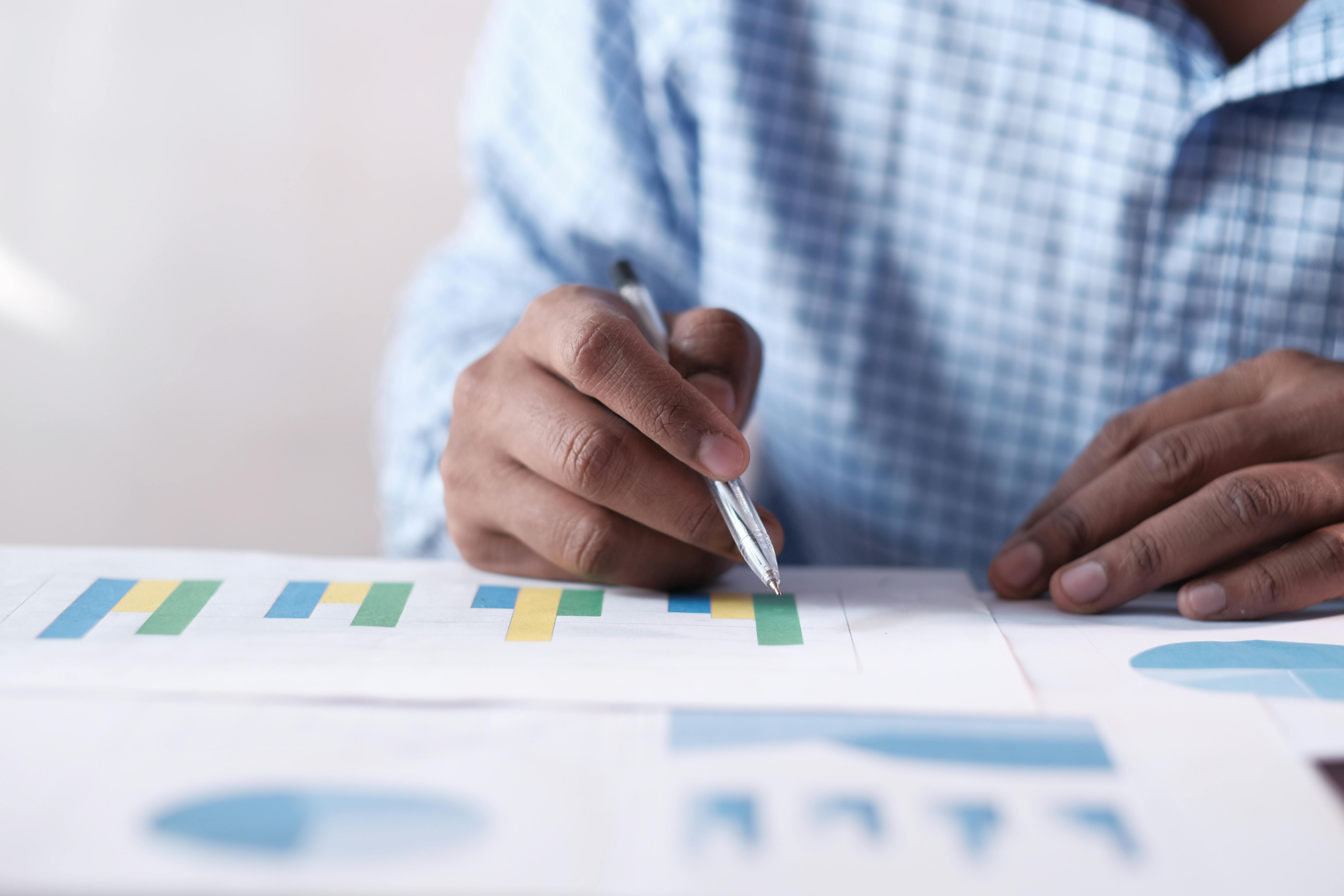 kenson Investments | Collateral Transparency and Market Discipline professional analyzing financial charts and collateral data with pen to evaluate market exposure and reserve stability