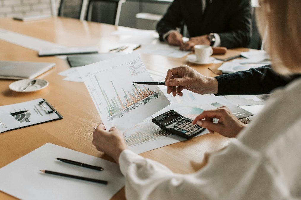 kenson Investments | The Structural Role of Collateral in Digital Financial Systems professional reviewing financial charts with calculator during market analysis meeting