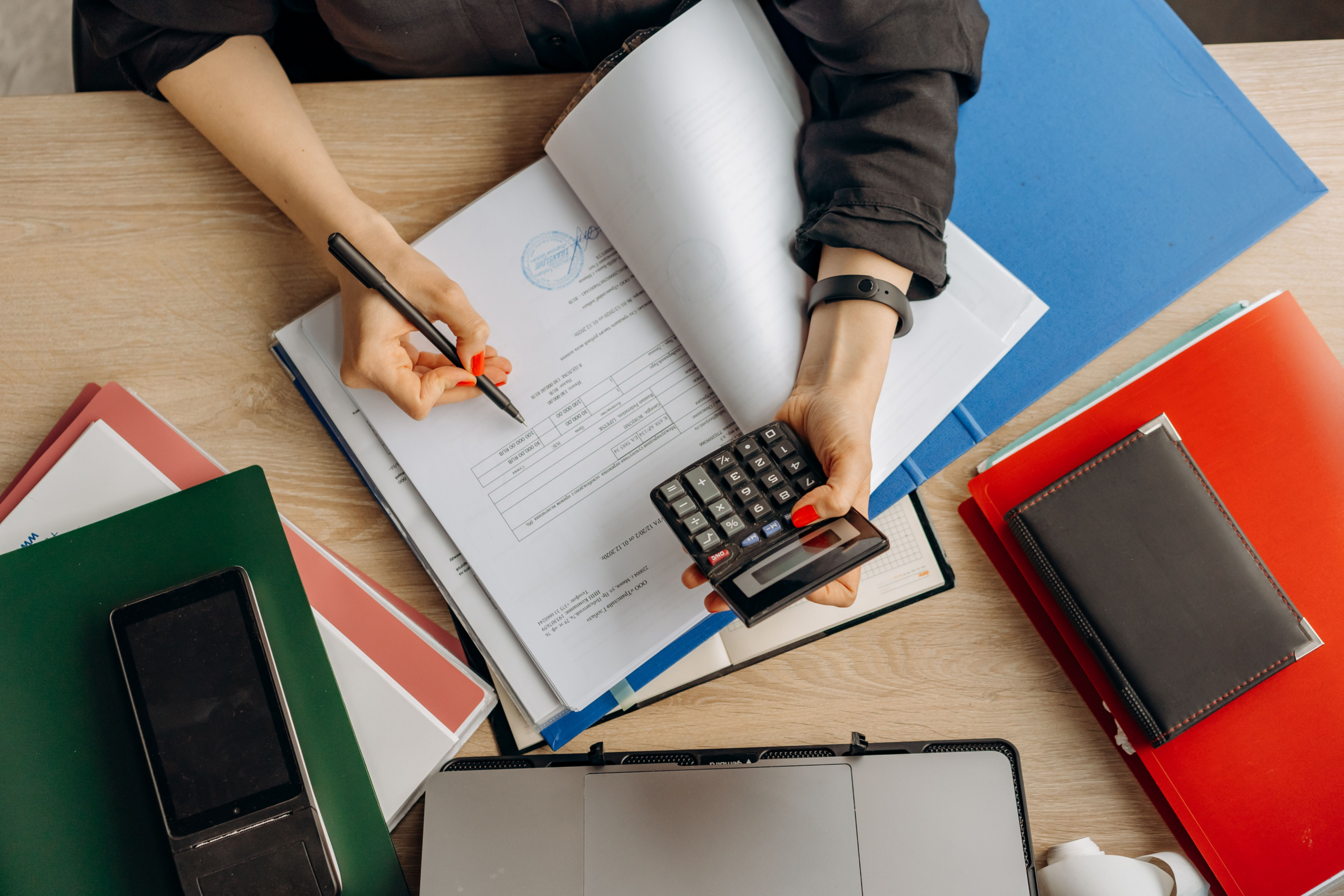 Professional reviewing financial documents with a calculator