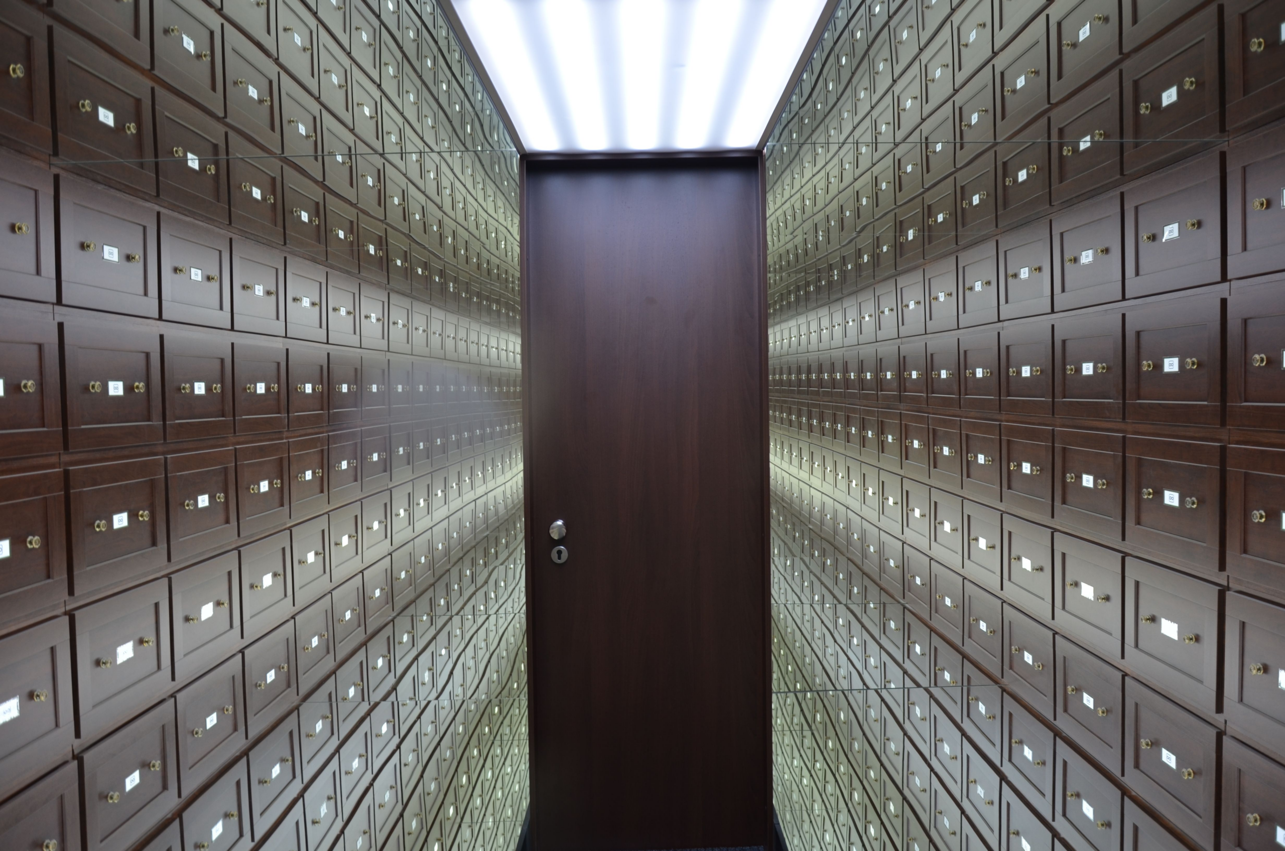 kenson Investments | Tokenized Securities Without the Wrapper: What DTCC’s Pilot Changes for Institutional Ownership Secure bank vault lined with individual deposit boxes