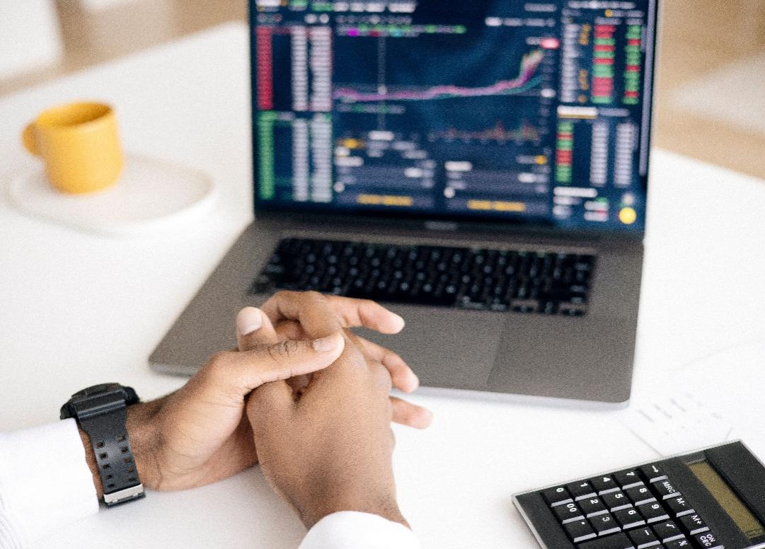 kenson Investments | The New Reporting Burden Behind Digital Asset Tax Transparency Person reviewing financial charts and transaction data on a laptop.