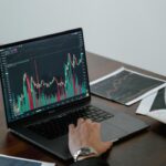 kenson Investments | Tokenized Collateral and Margin Workflows: Faster Movement Needs Better Controls Person reviewing financial charts and data on a laptop.
