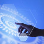 kenson Investments | The Shift From Token Issuance to Asset Servicing Close-up of a hand pointing toward a digital currency display on a blue glowing blockchain node network background.