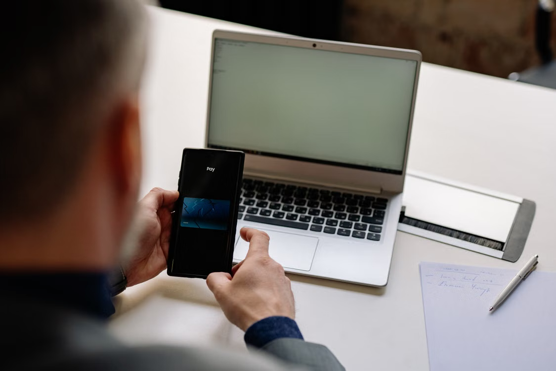 A businessperson processing a digital payment transaction on a mobile device. 