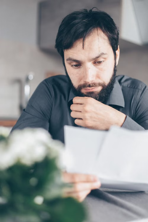 A close-up of a person reviewing financial risk documents at a desk.