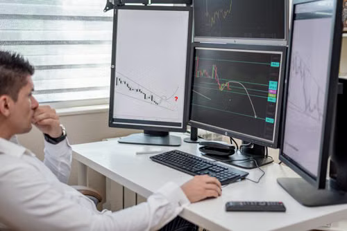 A financial analyst reviewing fund flow data across multiple monitors.