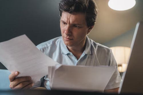 Compliance officer reviewing EU financial regulation documents related to crypto-asset licensing.