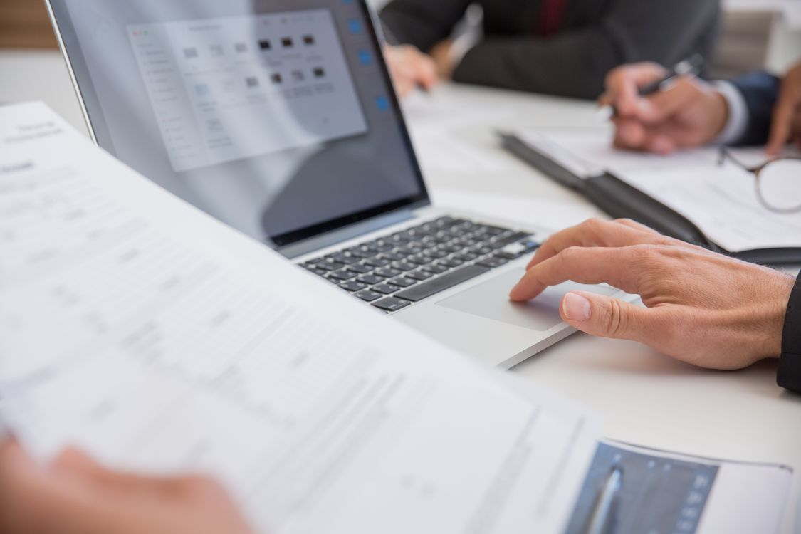 kenson Investments | Understanding the CLARITY Act: Why Digital Asset Regulation Matters A professional reviewing compliance documents and digital asset regulatory frameworks on a laptop.