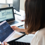 Financial analysts reviewing blockchain settlement data on office computer screens