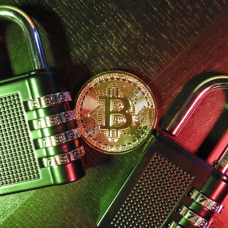 Bitcoin coin with combination padlocks on a wooden surface