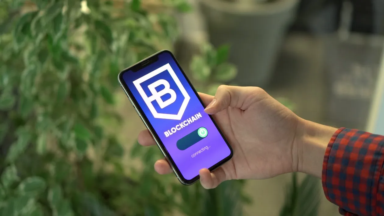 Close-up of a smartphone showing a blockchain app screen held by a hand..