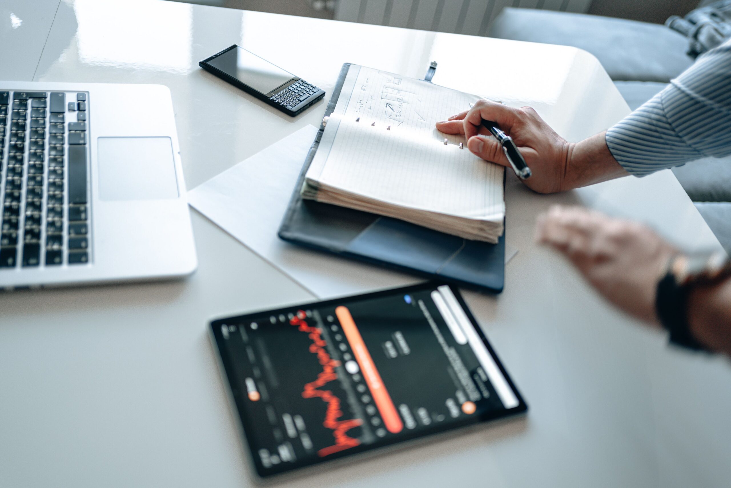 Financial professional analyzing securities market data on a computer while taking notes