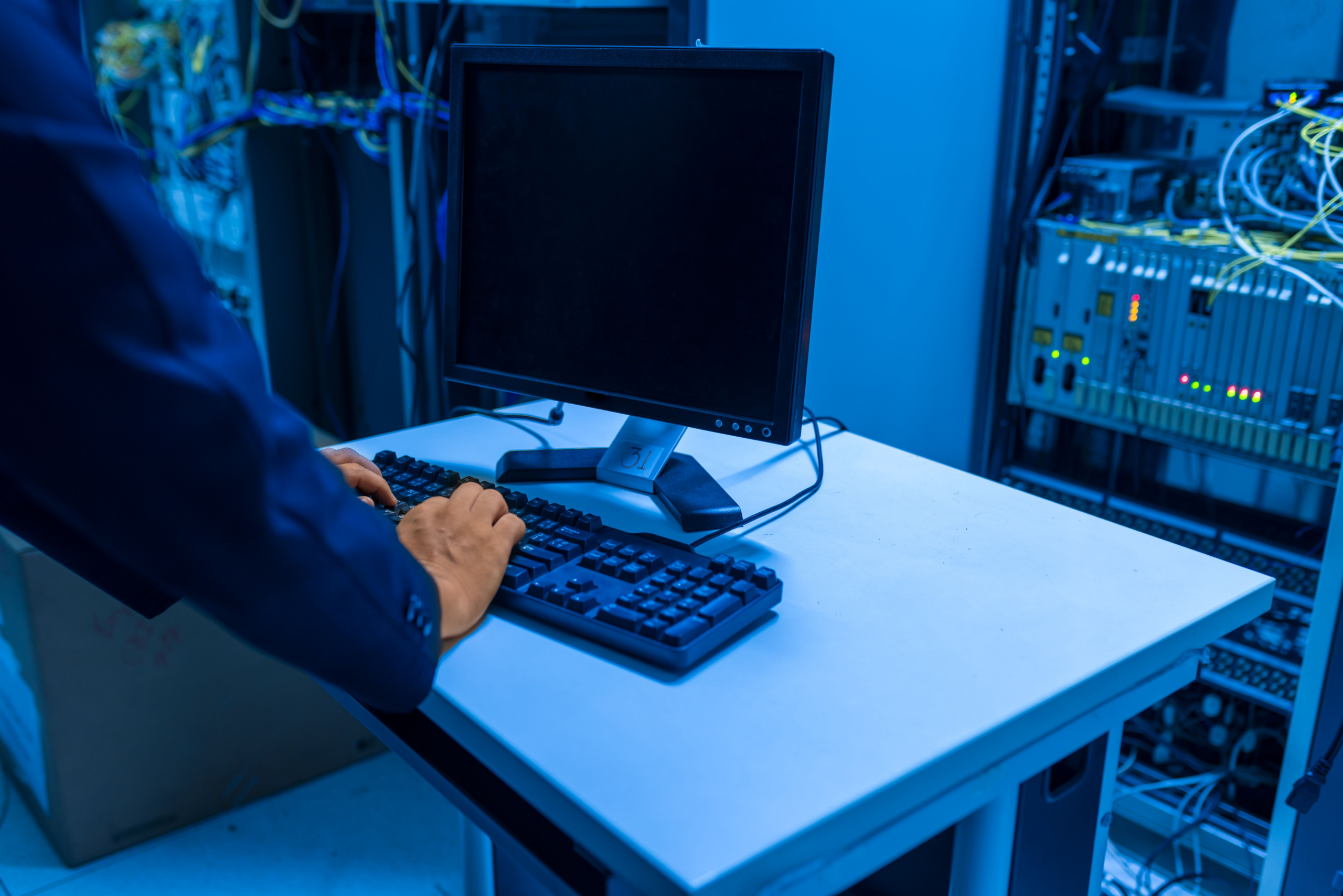 kenson Investments | Tokenized Repo Is Processing $365 Billion a Day: Has DLT Quietly Passed the Institutional Scale Test? IT technician managing connected server infrastructure inside a data center