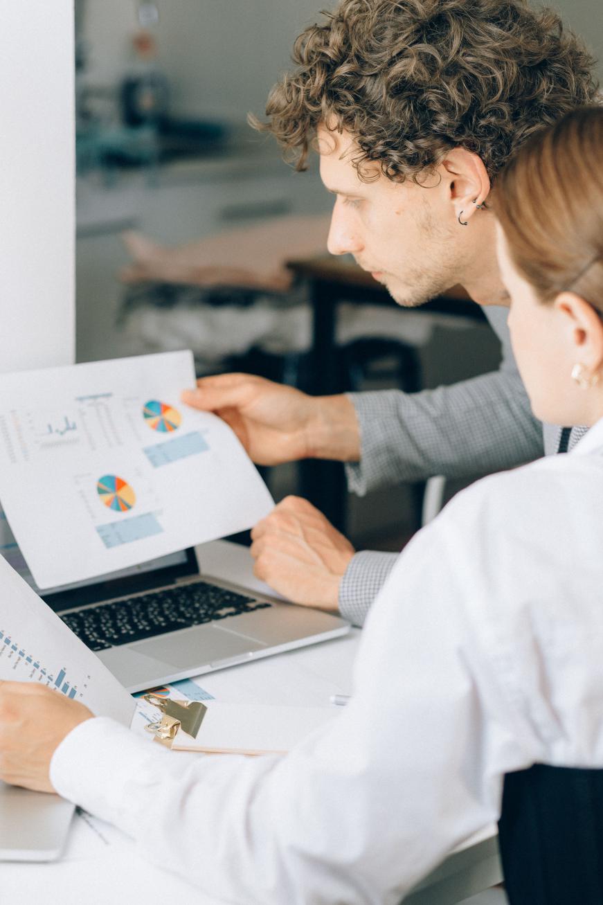 kenson Investments | Pontes Moves Tokenized Settlement From Trial to Operating Service Business professionals reviewing financial charts and laptop data during an office meeting