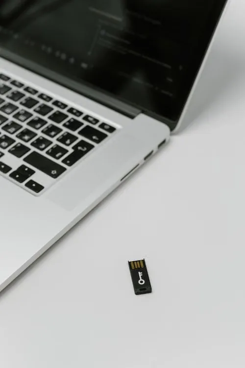 close-up of a USB security key beside a laptop
