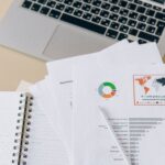 Financial documents beside a laptop representing regulated bond records, depository infrastructure, and ownership documentation