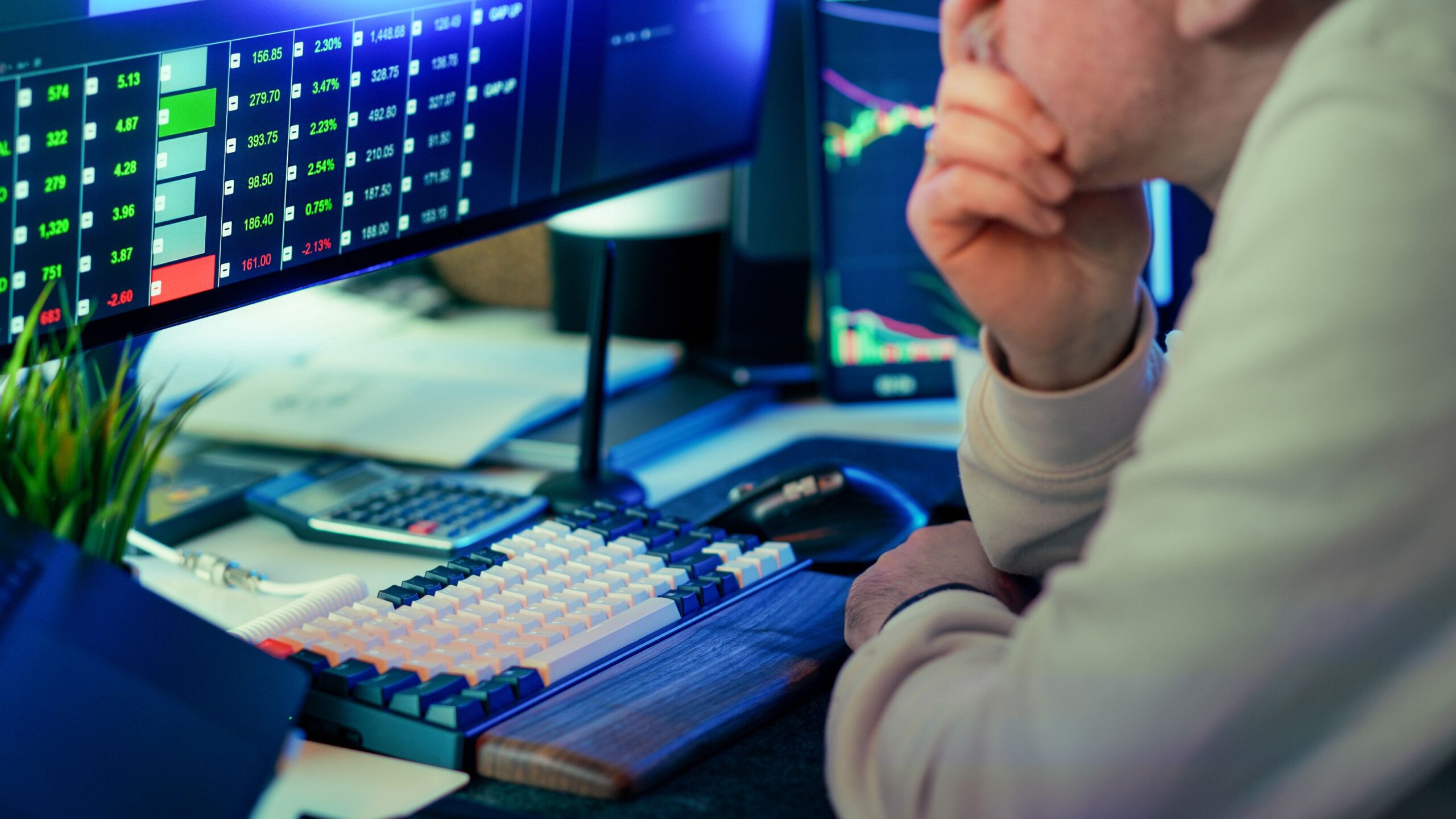 Trader monitoring financial market data across multiple screens in a modern trading workspace