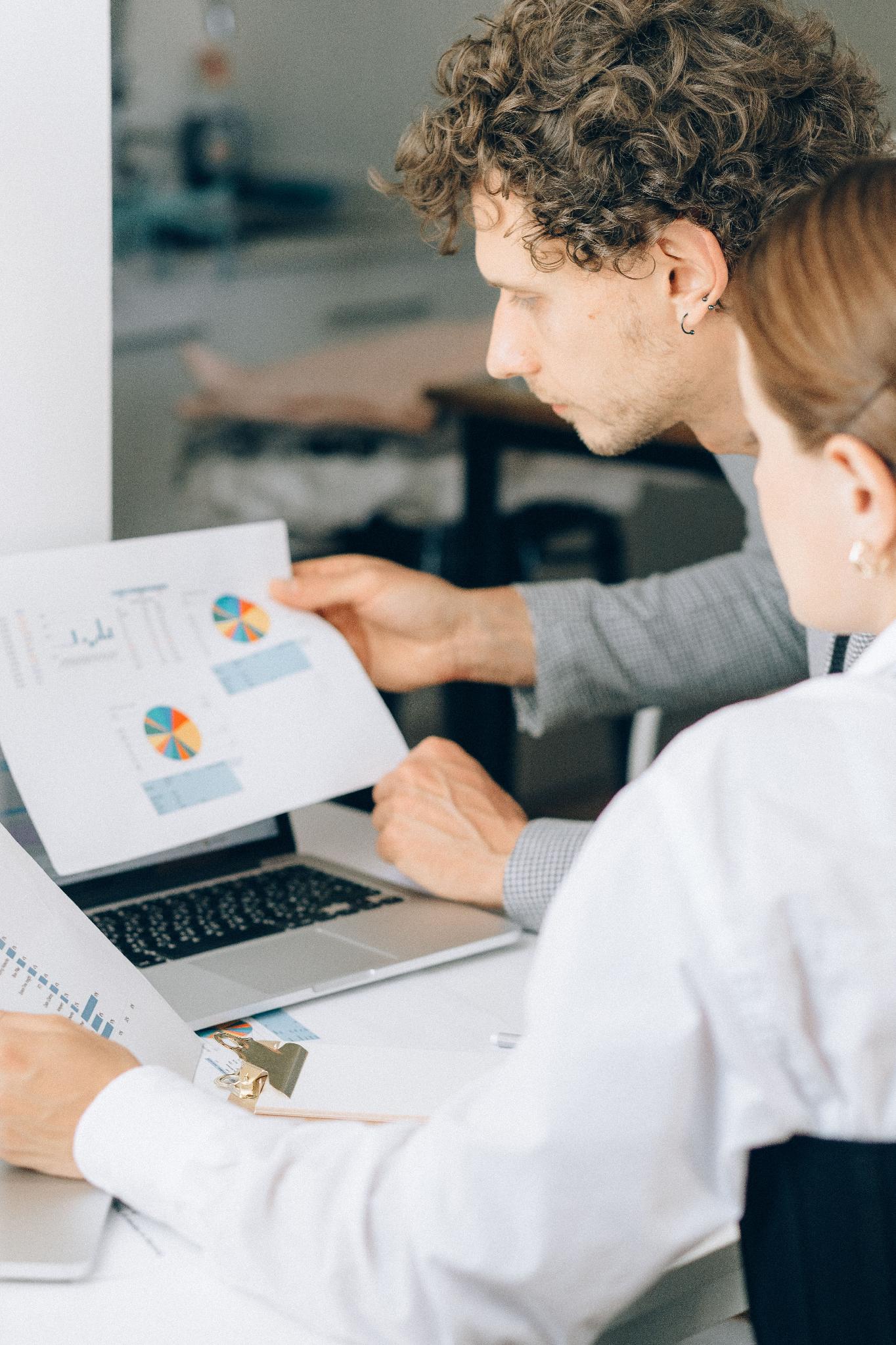 Finance professionals reviewing financial reports and reserve data in an office