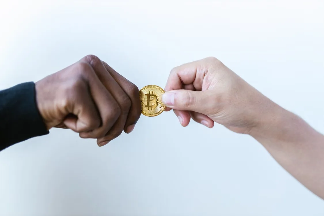 kenson Investments | Order Cancellation Races: Why an Acknowledgement Does Not Erase a Fill Person holding a Bitcoin coin between their hands.