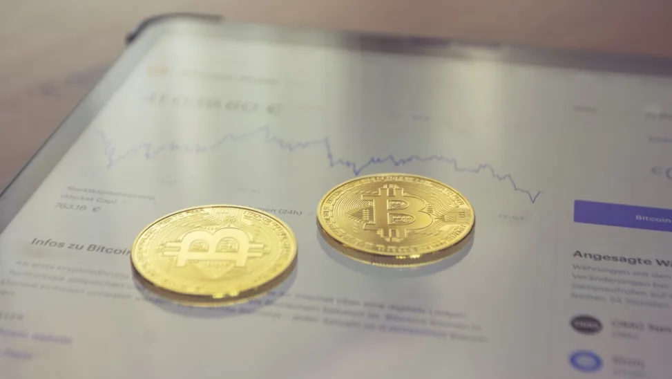 kenson Investments | Bitcoin Transaction Replacement: Fees, Conflicts, and Pinning Gold coins displayed on a tablet screen.