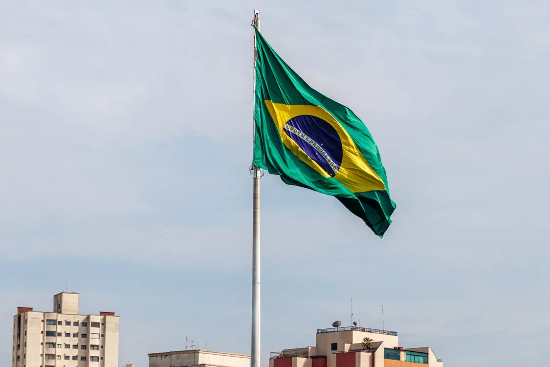 Brazilian flag waving against São Paulo skyline