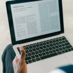A person reviewing an official digital asset industry announcement alongside a news article on a computer screen.