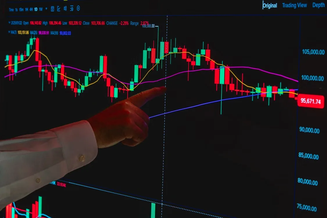 kenson Investments | Crypto Vaults Explained: Five Risks to Understand Before Evaluating Digital Asset Lending Hand pointing at stock market graph on a digital screen