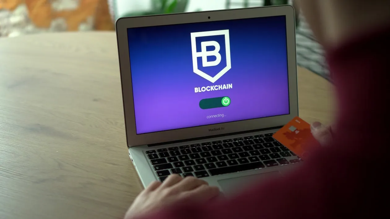 kenson Investments | Crypto Security Incidents Are a Reminder to Examine Custody Before Market Performance Person using laptop displaying blockchain login screen while holding card.