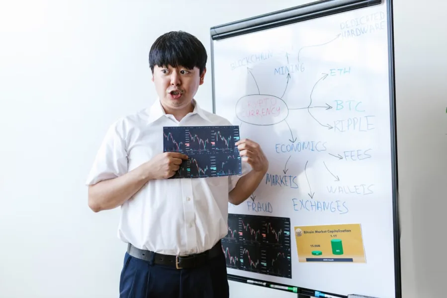 kenson Investments | Rebasing and Transfer-Fee Tokens: Reconciling Quantity Changes Man holding a sheet of data for review.