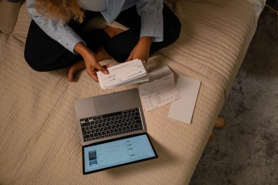 kenson Investments | Crypto Platforms and Banking: What Convergence Could Mean for Digital Asset Users A person reviewing account terms, security settings, and financial documents on a laptop before using an integrated banking and cryptocurrency platform.