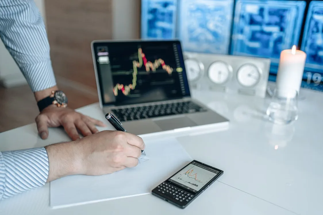 kenson Investments | Self-Trade Prevention: Cancel-Maker, Cancel-Taker, and Decrement Rules Person writing notes on a sheet of white paper.
