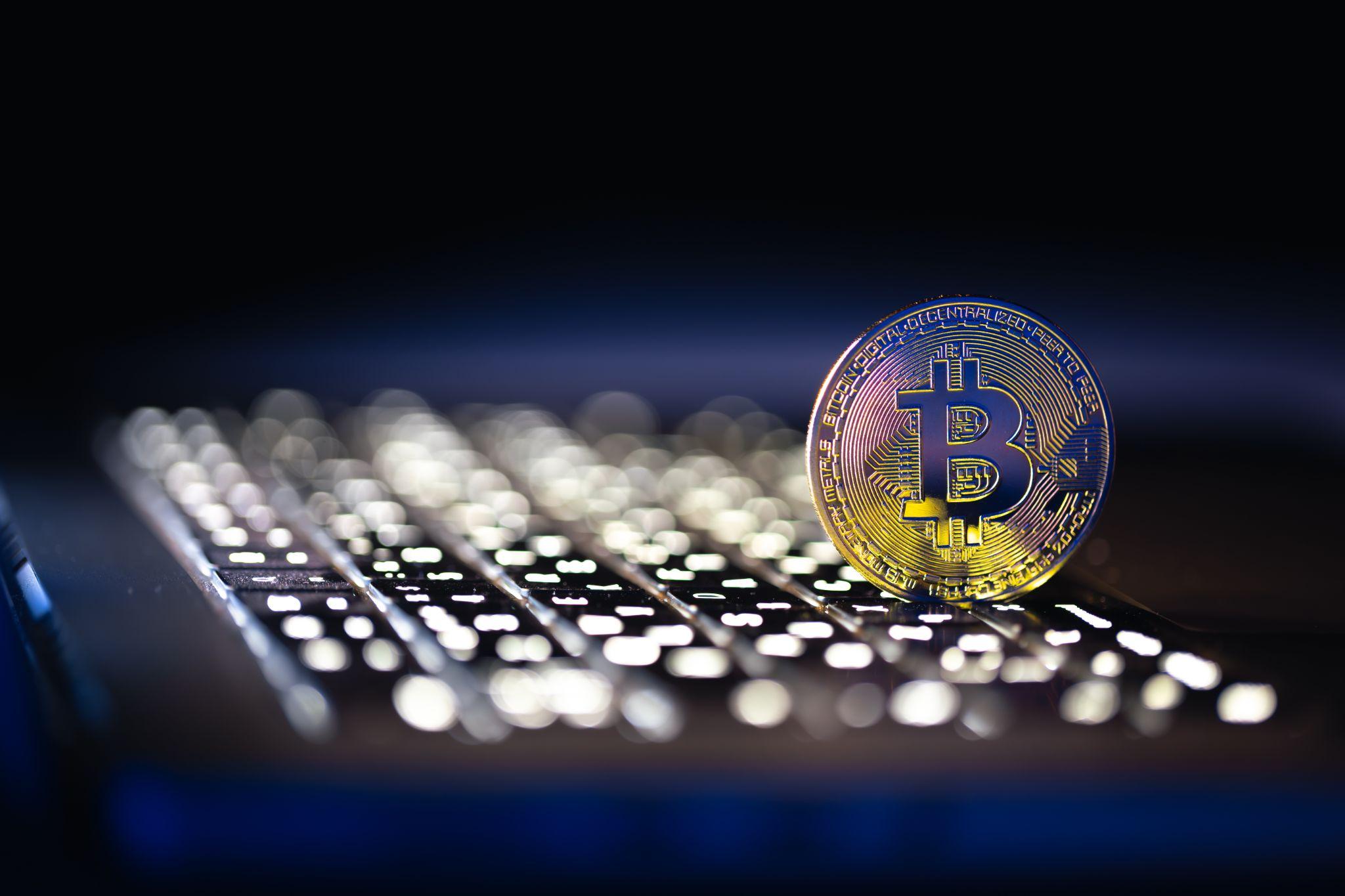 Cryptocurrency coin on a computer keyboard representing digital asset valuation, trading activity, and NFT liquidity considerations.