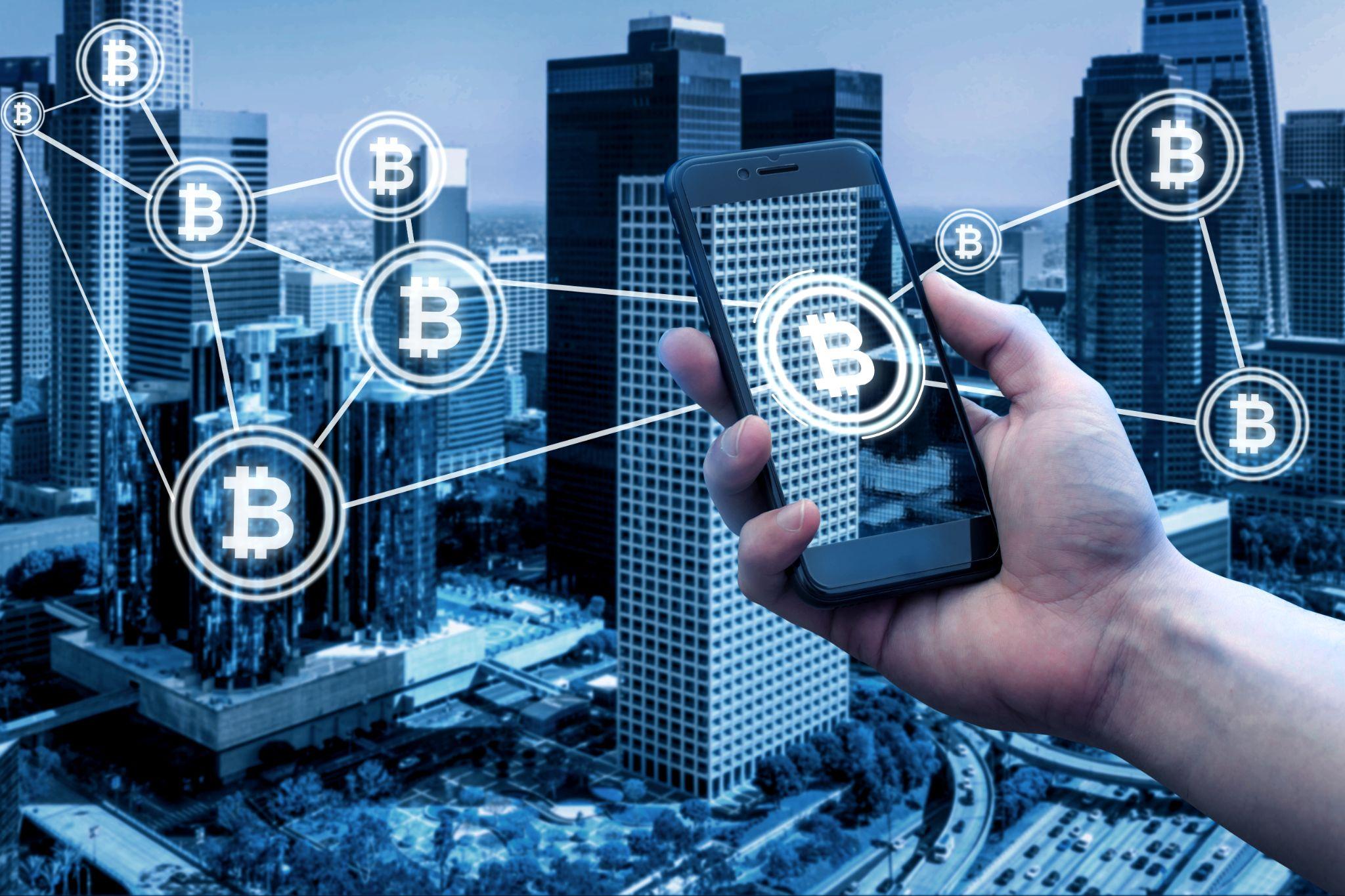 Smartphone with blockchain symbols over a city skyline representing SPV structures and digital ownership in tokenized real estate.