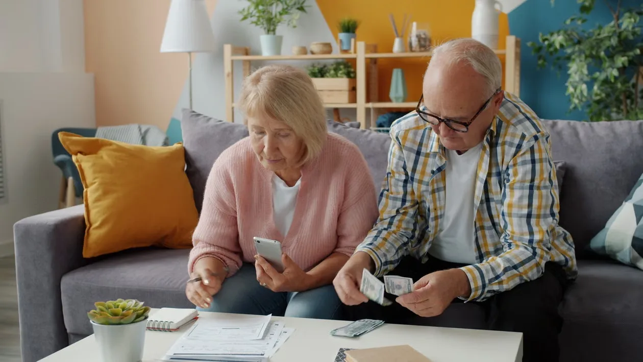 Senior couple reviewing household finances together indoors.