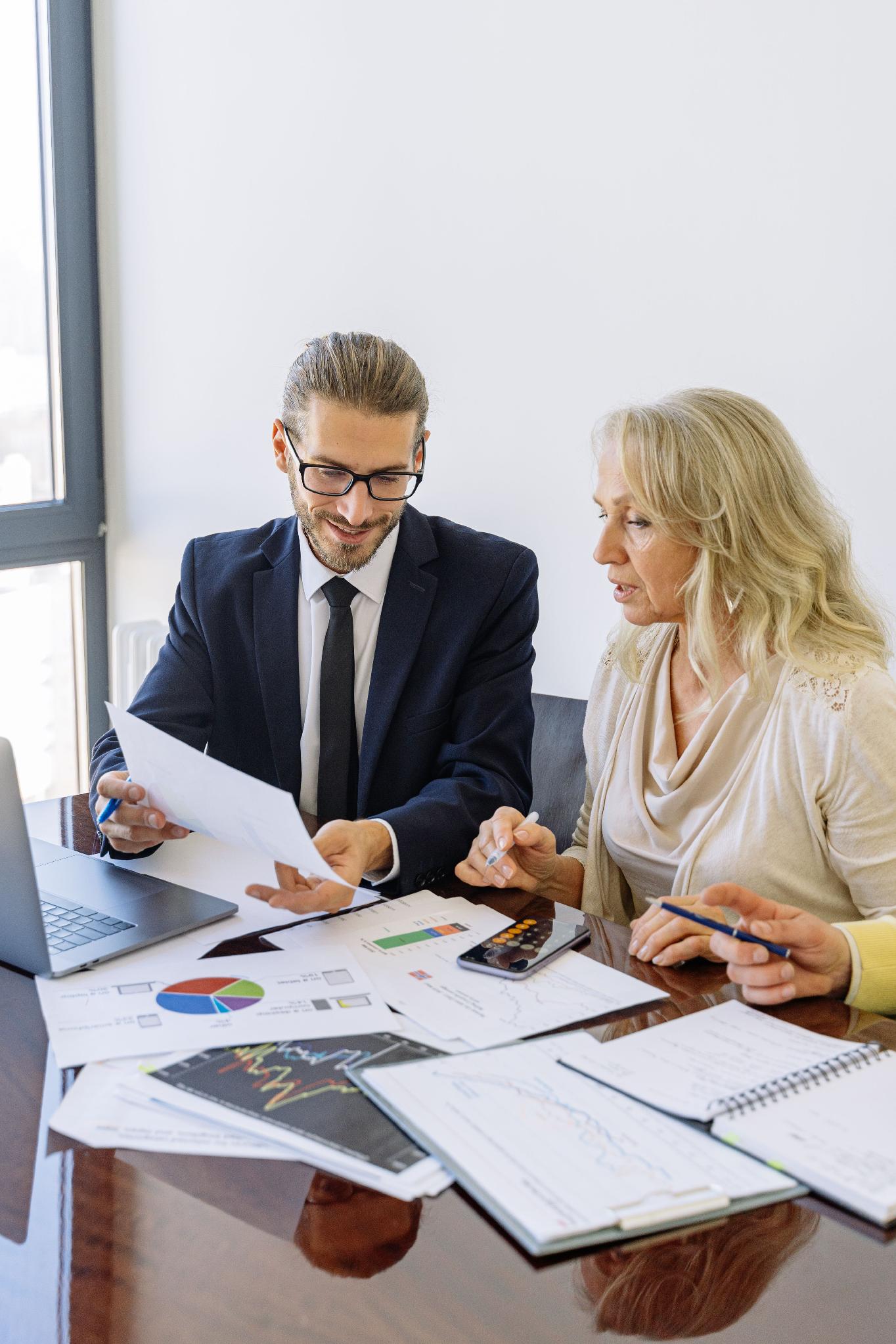 Business professionals reviewing financial reports and supporting documentation