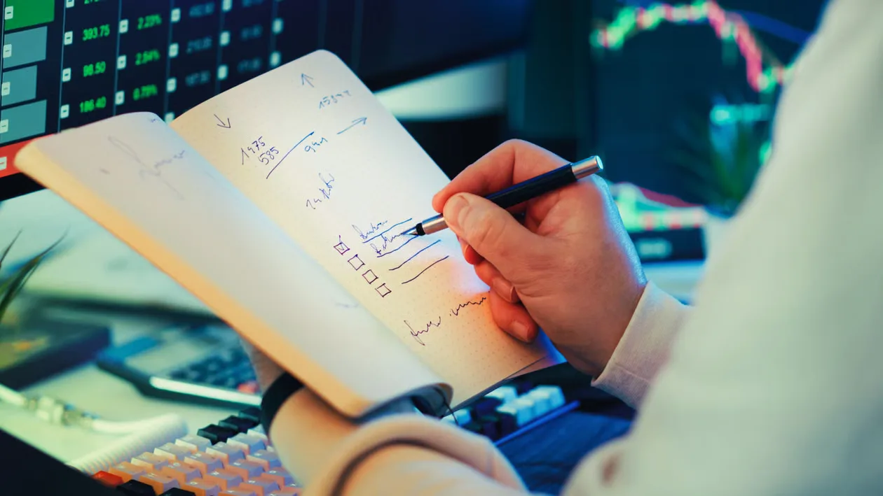 A businessman writes notes in a notebook