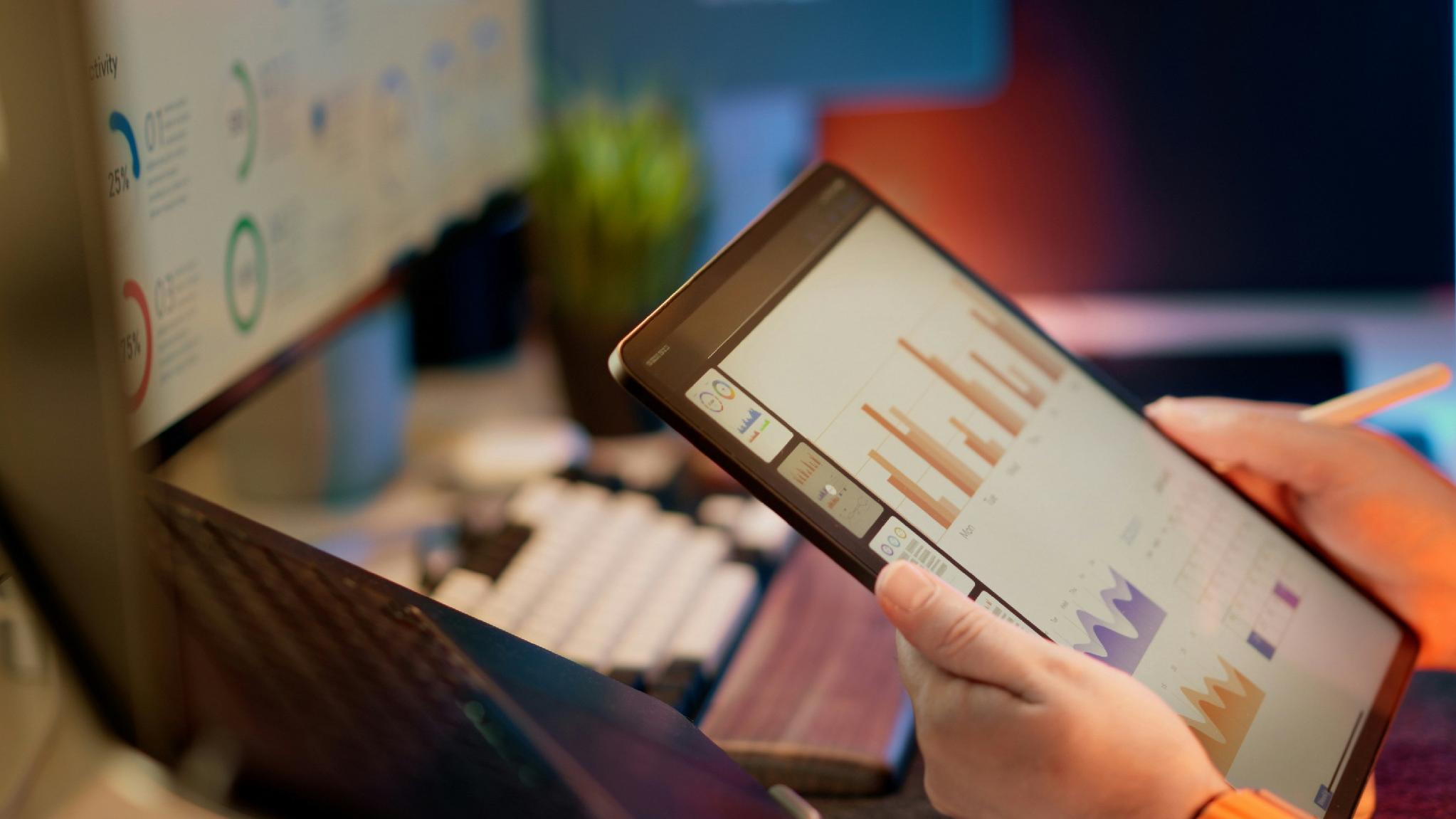 Analyst reviewing financial data and charts on a tablet for digital asset due diligence