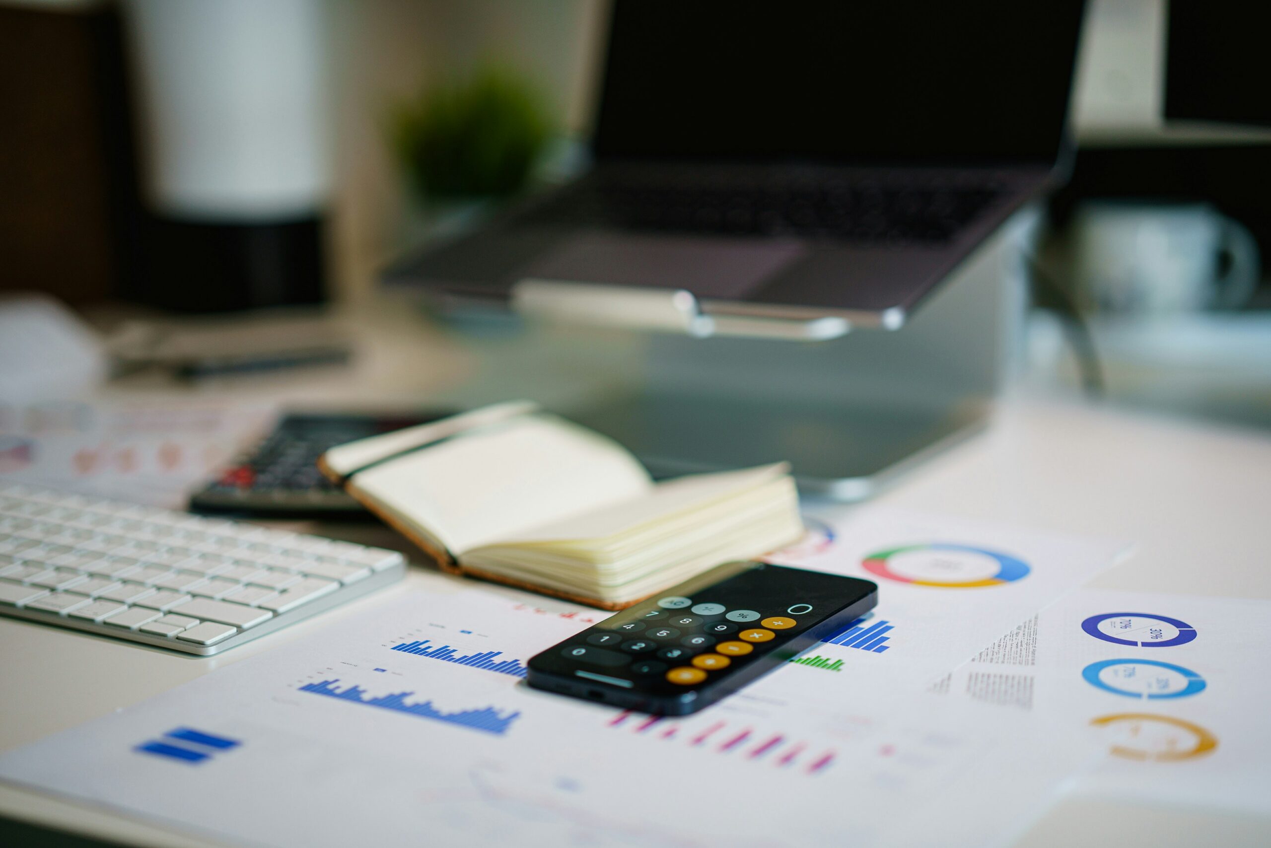 Office desk with financial charts, calculations, smartphone, and business documents used for cash flow analysis